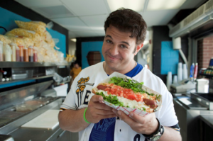 The Travel Channel's Adam Richman enjoys a Homewrecker during his visit to The Joe to shoot an episode of Man v. Food, RiverDogs Facebook photo.